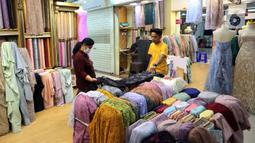 Pedagang kain bahan melayani pembeli di Pasar Tanah Abang, Jakarta, Rabu (18/5/2022). Kementerian Perindustrian memproyeksikan industri tekstil dan produk tekstil (TPT) bakal tumbuh 3,5 persen pada semester I/2022. (Liputan6.com/Angga Yuniar)