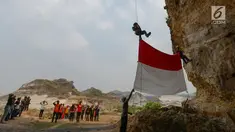 Pegiat alam bebas dan Kelompok Pecinta Lingkungan Gembala mengibarkan bendera merah putih pada HUT ke-74 RI di lokasi bekas tambang Tebing Arpam, Guha Tugu Gula, Klapanunggal, Kabupaten Bogor, Sabtu (17/8/2019). Upacara tersebut sebagai bentuk pelestarian kawasan karts. (merdeka.com/Imam Bukhori)
