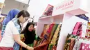 Pengunjung melihat produk Rumah Kain Palembang di booth YDBA pada Jakarta Fair Kemayoran 2019 di JIExpo Kemayoran, Jakarta, Rabu (19/6/2019). YDBA mengikutsertakan 40 UMKM mulai dari produk fashion, aksesoris, kerajinan, alat rumah tangga hingga makanan hingga 30 Juni 2019. (Liputan6.com/HO/Eko)