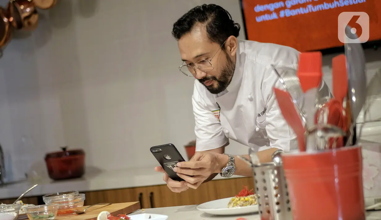 Chef Norman saat mengabadikan foto hasil hidangan bernutrisi menggunakan bahan-bahan dari daftar "50 Pangan untuk Masa Depan” di Jakarta, Selasa (26/01/2021). (Liputan6.com/Pool)