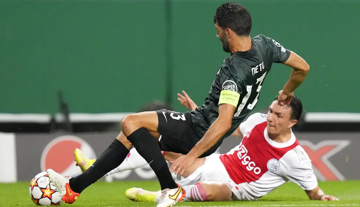 Pemain Sporting CP Luis Neto (kiri) berebut bola dengan pemain Ajax Steven Berghuis pada pertandingan Grup C Liga Champions di Stadion Alvalade, Lisbon, Portugal, Rabu (15/9/2021). Ajax menang 5-1. (AP Photo/Armando Franca)