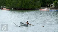 Seorang anak mendayung sampan di Pulau Bunaken, Manado, Sabtu (17/12). Taman Nasional Laut yang terletak di Provinsi Sulawesi Utara ini memiliki keindahan alam dan biota laut. (Liputan6.com/Fery Pradolo)