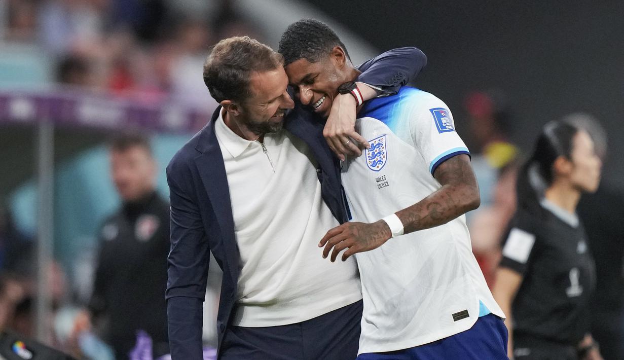 <p>Pelatih Inggris, Gareth Southgate memeluk pemainnya, Marcus Rashford saat matchday ketiga Piala Dunia 2022 melawan Wales di Ahmad Bin Ali Stadium, Rabu (30/11/2022). (AP/Frank Augstein)</p>