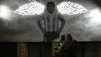 Perempuan berpelukan di dekat mural mendiang legenda sepak bola dunia, Diego Maradona di Buenos Aires, Argentina, Selasa malam (23/11/2021). Peringatan pertama kematian Maradona digelar pada 25 November 2021. (AP Photo/Rodrigo Abd)