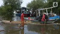 Aktivitas warga di pantai Marunda dan kawasan Si Pitung, Jakarta, Kamis (9/12/2021). Di beberapa titik masih tergenang akibat banjir rob (air laut pasang) dan gelombang  pasang air laut merupakan masalah serius yang dihadapi beberapa wilayah pesisir di Indonesia. (merdeka.com/Imam Buhori)