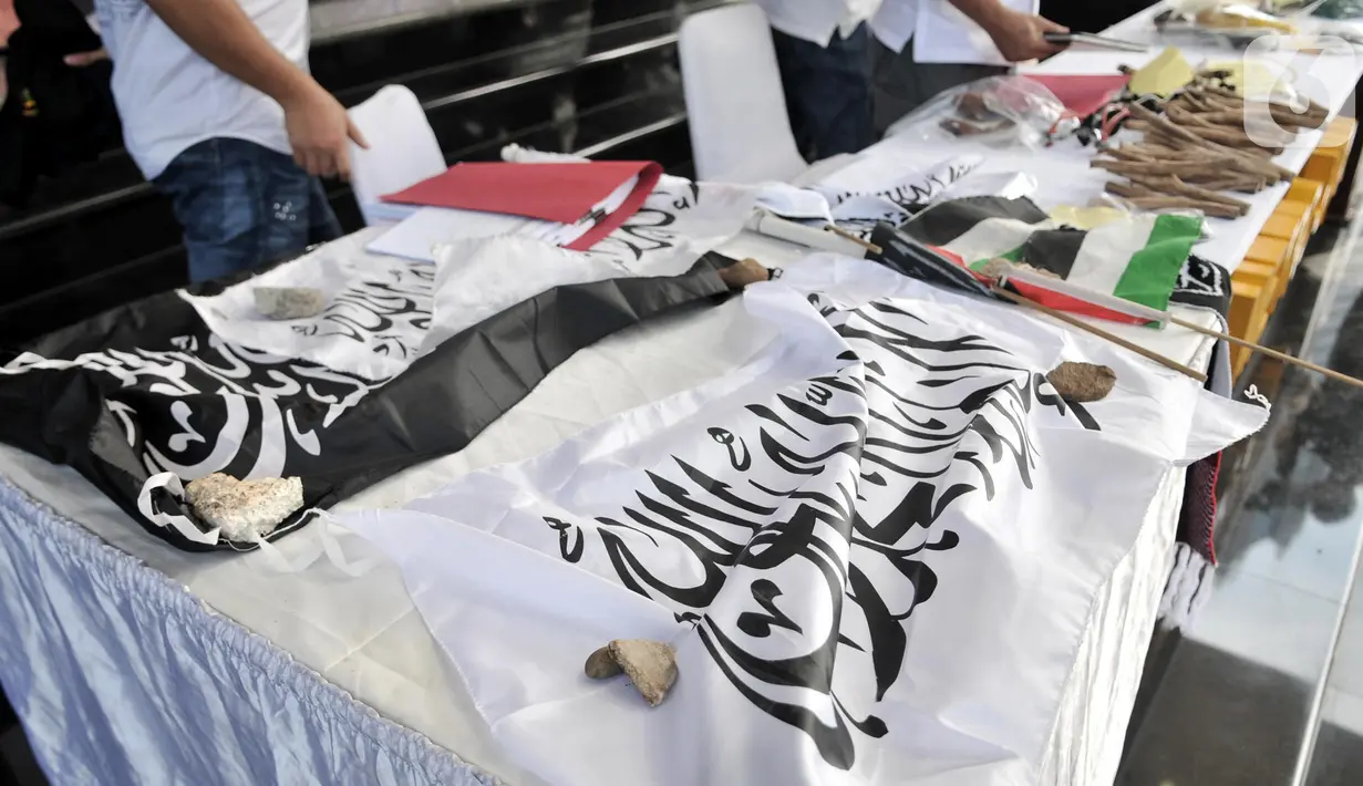 Barang bukti bendera berlafaz Alquran dihadirkan saat rilis pengungkapan rencana tindak kejahatan dalam pelantikan presiden dan wakil presiden di Mapolda Metro Jaya, Jakarta, Senin (21/10/2019). Polisi juga menyita ketapel, peluru, bola berisi bahan peledak, dan mobil. (merdeka.com/Iqbal Zakharia)
