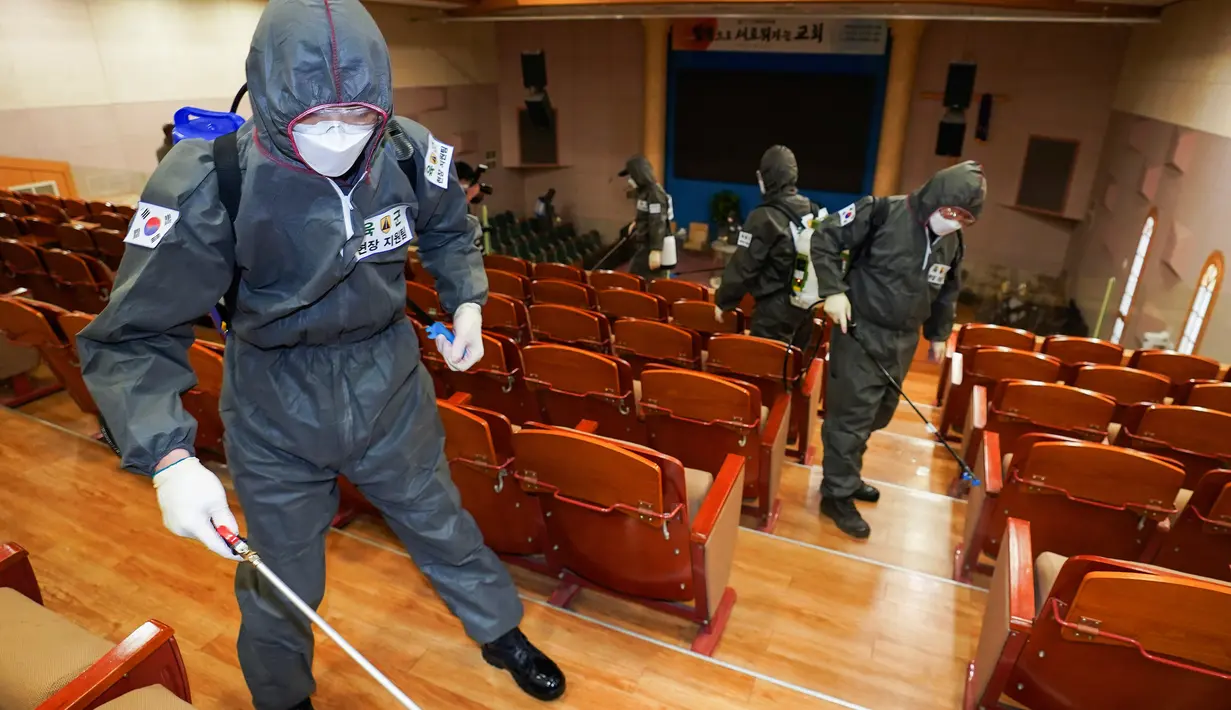 Tentara Korea Selatan yang mengenakan pakaian pelindung menyemprotkan desinfektan di sebuah gereja di Seoul,Selasa (3/3/2020). Seoul mengerahkan tentara untuk menyemprotkan disinfektan di jalan dan gang-gang untuk mencegah penyebaran virus corona COVID-19 . (Kim Do-hoon/Yonhap via AP)