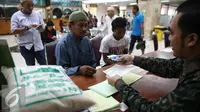 Seorang pria saat membayarkan zakat fitrah pada panitia amil zakat di Masjid Istiqlal, Jakarta, Jumat (1/7). Waktu pembayaran zakat fitrah dibuka hingga malam takbiran. (Liputan6.com/Faizal Fanani) 