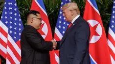 Presiden Amerika Serikat (AS) Donald Trump  berjabat tangan dengan Pemimpin Korea Utara, Kim Jong-un dalam pertemuan bersejarah di resor Capella, Pulau Sentosa, Singapura, Selasa (12/6). Trump dan Kim berjabat tangan untuk pertama kalinya. (AP/Evan Vucci)
