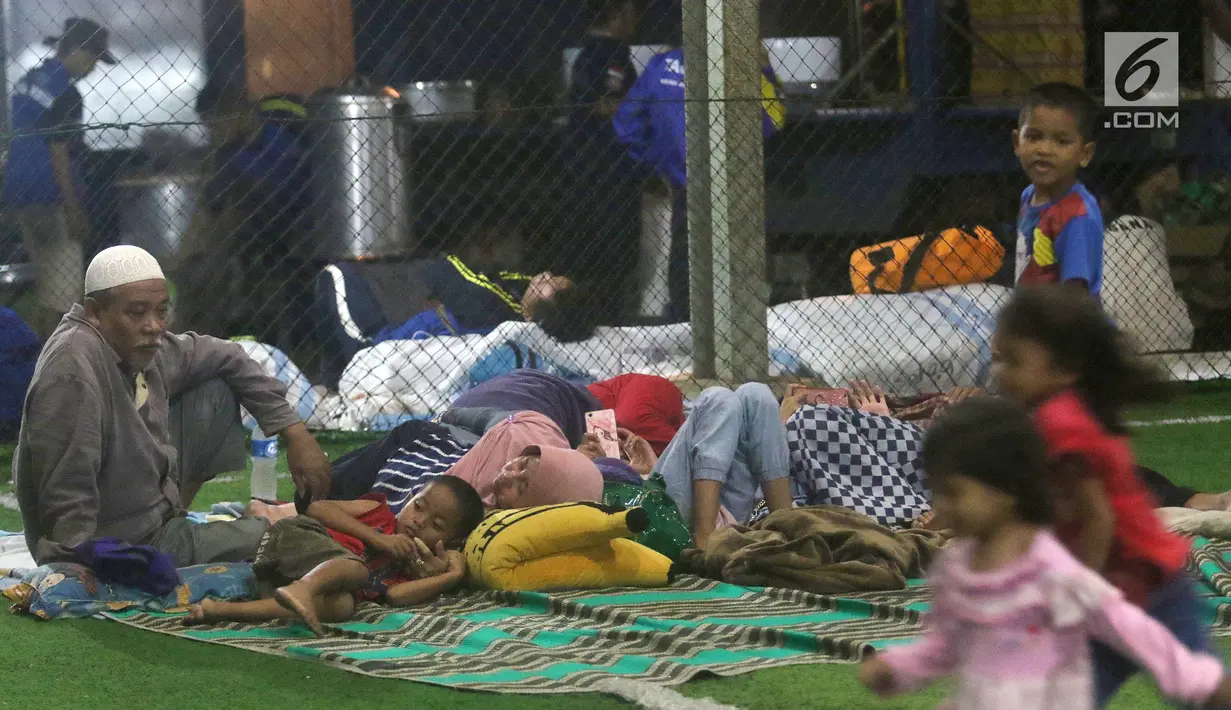 Warga korban Tsunami Anyer mengungsi di lapangan futsal Labuan, Banten, Minggu (23/12). Warga memilih mengungsi menunggu suasana di pesisir Pantai Selat Sunda pulih dan kondusif. (Liputan6.com/Angga Yuniar)