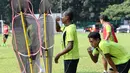 Yustinus Pae (kiri) dan Yohanis Tjoe berteduh dari sengatan matahari saat jeda latihan. (bola.com/Arief Bagus)