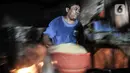 Perajin membawa rendaman biji kedelai yang akan diolahnya menjadi tempe di kawasan Sunter, Jakarta, Senin (4/1/2021). Perajin tempe setempat berupaya mengurangi kerugian akibat melonjaknya harga kedelai impor dengan memperkecil ukuran tempe dan menaikan harga jual. (merdeka.com/Iqbal S. Nugroho)