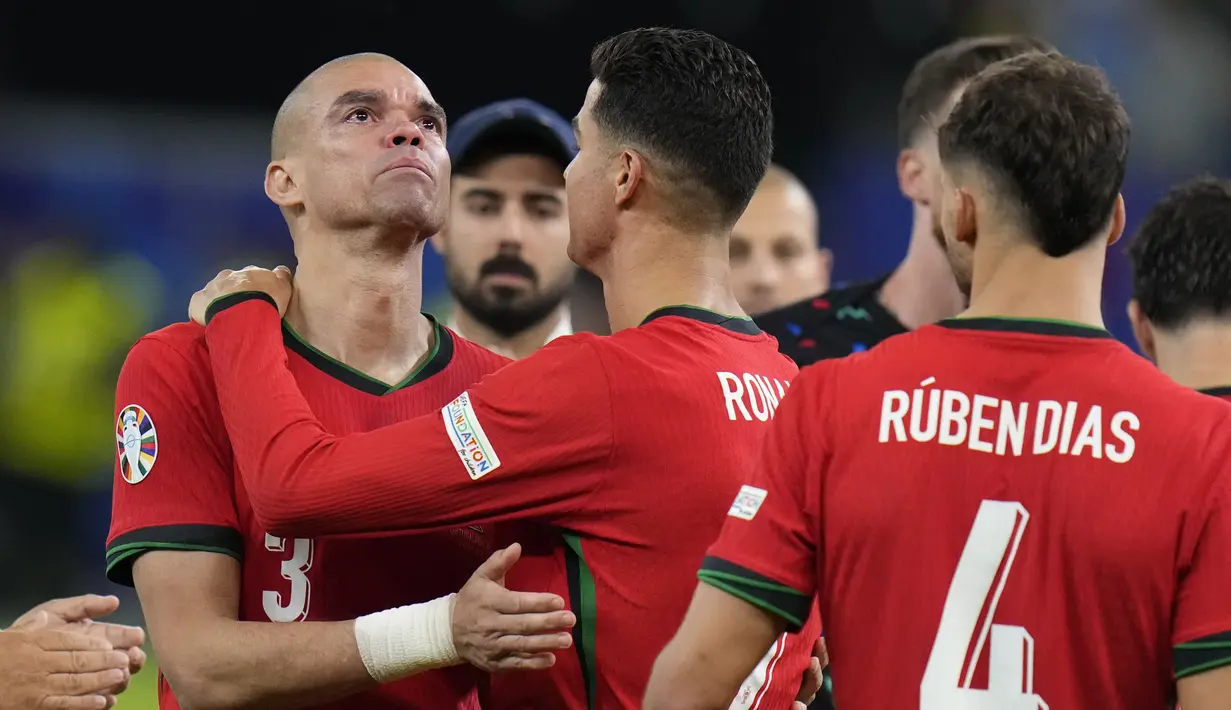 Usai kalah adu penalti, bek veteran Portugal Pepe tampak menangis. Ronaldo kemudian hadir mendekati koleganya tersebut dan memeluknya. (AP Photo/Hassan Ammar)