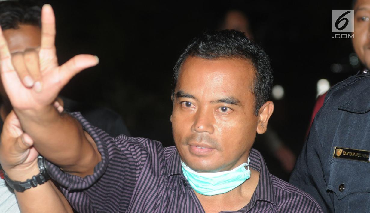 Bupati Purbalingga Tasdi mengacungkan salam saat tiba di Gedung KPK, Jakarta, Selasa (5/6). Tasdi terjaring Operasi Tangkap Tangan KPK bersama lima orang lainya yakni sejumlah pejabat daerah Purbalingga dan pihak swasta. (Merdeka.com/Dwi Narwoko)