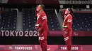 Hary Susanto dan Leani Ratri Oktila memberi hormat kepada bendera sambil menyanyikan lagu kebangsaan setelah menerima medali emas pada ganda campuran cabang badminton nomor SL3-SU5 Paralimpiade Tokyo 2020, Minggu (5/9/2021). Indonesia menambah medali emas lewat Hary/Leani. (AP/Kiichiro Sato)