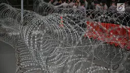 Kawat berduri dua lapis dipasang di depan Kedutaan Besar Myanmar, Jakarta, Rabu (6/9).  Jelang aksi kedubes Myanmar dikelilingi oleh kawat berduri dan dijaga polisi bersenjata lengkap serta kendaraan taktis water cannon. (Liputan6.com/Faizal Fanani)