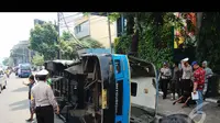 Bus Kopami dalam posisi terguling  di badan jalan, sedangkan busway masih di lokasi kejadian. Petugas pun sudah berdatangangan mengamankan lokasi, Jakarta, Rabu (30/7/2014) (Liputan6.com/Faizal Fanani)