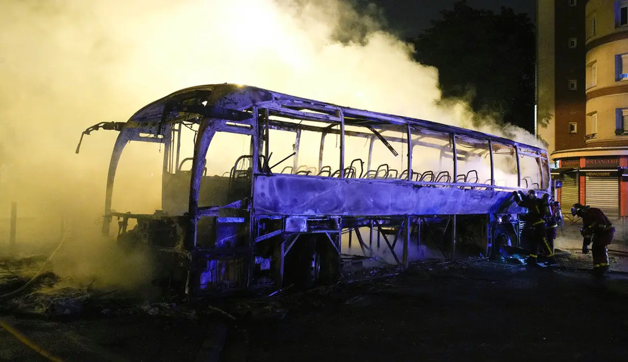 <p>Bangunan dan kendaraan telah dibakar sementara toko-toko dijarah. Kekerasan telah menjerumuskan Presiden Emmanuel Macron ke dalam krisis paling parah dalam kepemimpinannya sejak protes Rompi Kuning yang dimulai pada 2018. (AP Photo/Lewis Joly)</p>