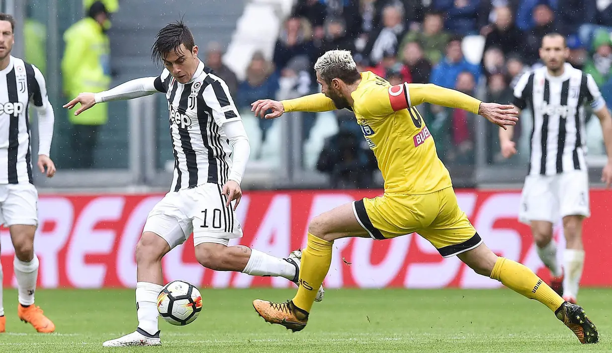 Striker Juventus, Paulo Dybala, berusaha melewati gelandang Udinese, Valon Behrami, pada laga Serie A di Stadion Allianz, Minggu (11/3/2018). Juventus menang 2-0 atas Udinese. (AP/Alessandro di Marco)