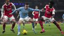 Pemain Manchester City, Phil Foden (tengah) berusaha melewati pemain Arsenal, Bukayo Saka (kanan) dan William Saliba pada laga pekan ke-23 Liga Inggris 2022/2023 yang berlangsung di Emirates Stadium, London, Kamis (16/02/2023) WIB. (AP Photo/Kin Cheung)