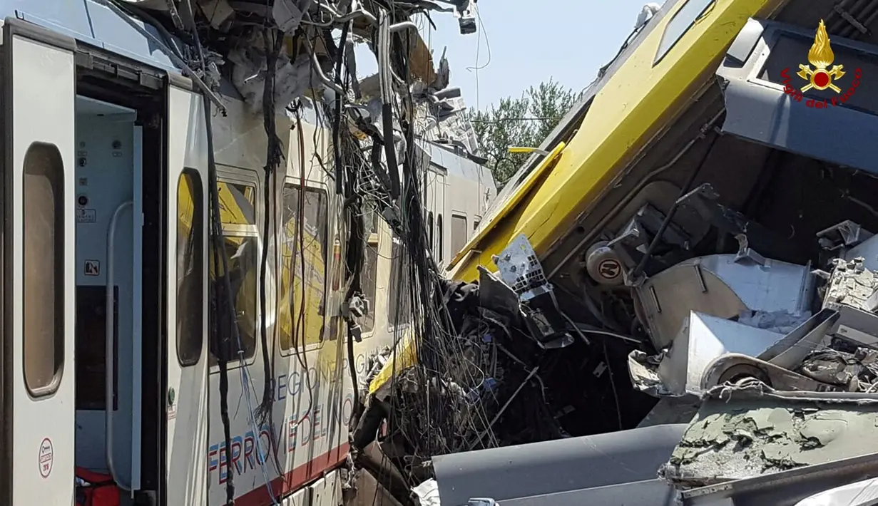 Kereta yang rusak berat akibat tabrakan yang terjadi di tengah kebun zaitun dekat desa selatan Corato, Bari, Italia, (12/7). Sedikitnya 11 orang tewas dan puluhan luka-luka akibat tabrakan kedua kereta tersebut. (Italian Firefighters/REUTERS)