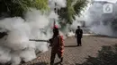 Petugas melakukan pengasapan (fogging) ke bagian pepohonan kawasan rumah warga, Pesanggrahan, Jakarta, Kamis (6/10/2022). Pengasapan ini diharapkan dapat mencegah penyakit DBD didaerah tersebut. (Liputan6.com/Johan Tallo)