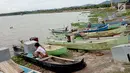 Seorang nelayan beraktivitas di dekat perahu yang bersandar di Danau Limboto, Gorontalo (20/12). Meskipun saat ini musim penghujan, Debit air Danau Limboto makin hari makin berkurang. (Liputan6.com/Arfandi Ibrahim)