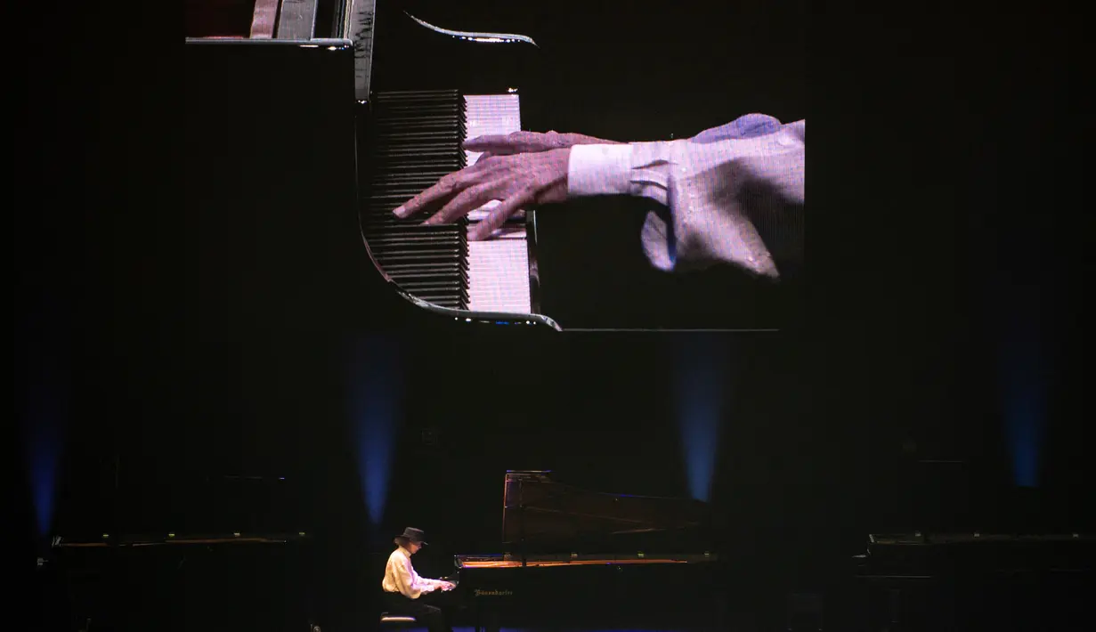 Sebuah panggung digambarkan dari area terbuka pusat perbelanjaan yang menampilkan pianis Takashi Kako tampil selama konser "The Pianist Special" di Tachikawa, Tokyo (11/4/2021). (AFP Photo/ Philip Fong)