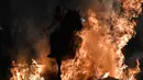 Seorang penunggang kuda melompati api unggun di desa San Bartolome de Pinares, Spanyol (16/1). Acara ini merupakan pembukaan dari festival keagamaan tradisional "Luminarias". (AFP Photo/Gabriel Bouys)