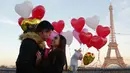 Gerson asal Honduras melamar pasangannya Andry pada Hari Valentine ketika berdiri di Trocadero Plaza dekat Menara Eiffel di Paris, Prancis (14/2). (AFP Photo/Ludovic Marin)