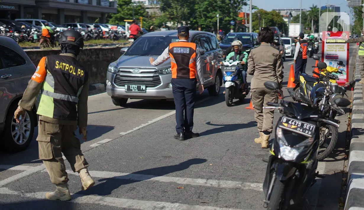 Petugas gabungan Satpol PP dan Dinas Perhubungan menggelar operasi kepatuhan disiplin masker di kawasan Waduk Sunter, Jakarta, Selasa (8/9/2020). Warga yang kedapatan melanggar akan dikenakan sanksi denda Rp 250 ribu atau membersihkan fasilitas umum. (Liputan6.com/Immanuel Antonius)