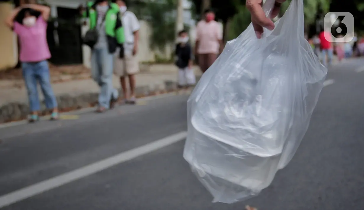 Warga membawa takjil yang didapatkan dari pembagian di Jalan Cempaka Putih Raya, Jakarta, Senin (11/5/2020). Setiap hari selama Ramadan, masyarakat sekitar membagikan 350 takjil kepada warga kurang mampu dan terdampak virus corona COVID-19. (Liputan6.com/Johan Tallo)