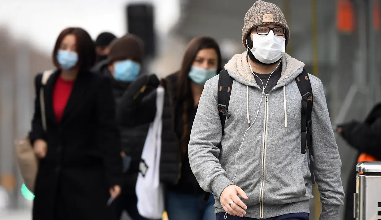 Komuter berjalan melewati Stasiun Flinders Street pada hari pertama wajib masker di tempat umum, di Melbourne, Kamis (23/7/2020). Penduduk kota terpadat kedua di Australia, Melbourne, diwajibkan mengenakan masker ketika meninggalkan rumah untuk mencegah penyebaran COVID-19. (William WEST/AFP)