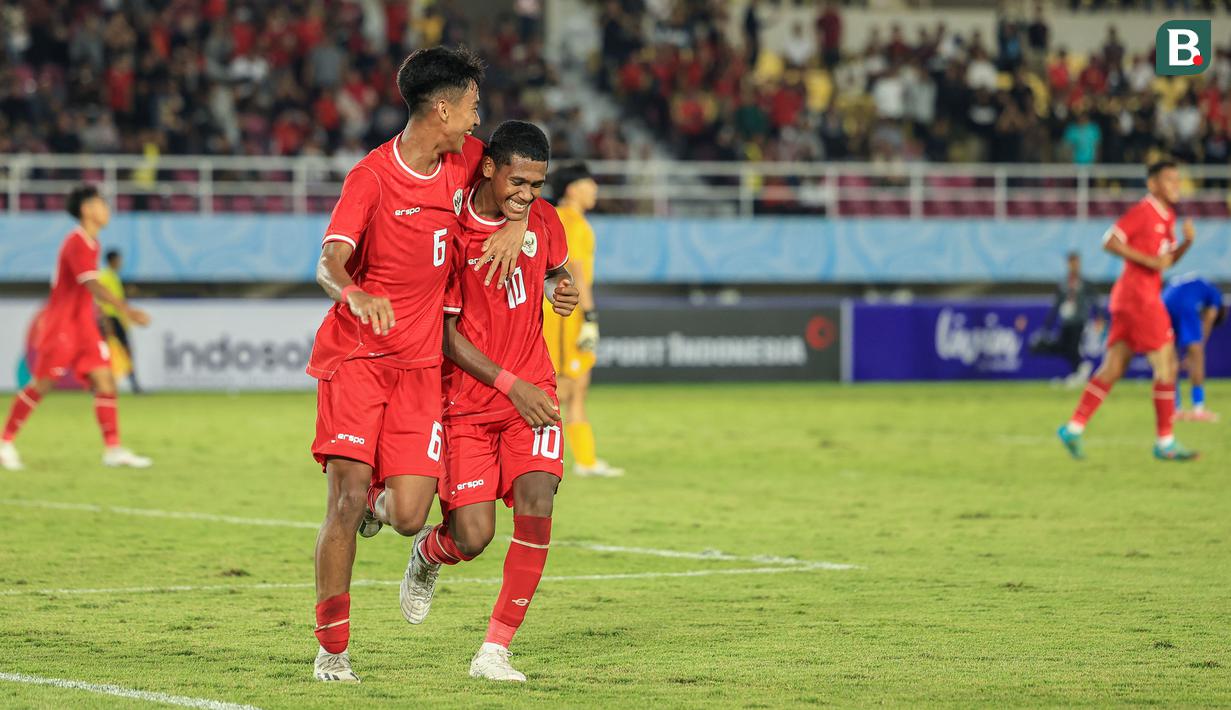 <p>Selebrasi striker Timnas Indonesia U-16, Fadly Alberto (kanan) bersama Evandra Florasta setelah mencetak gol ketiga ke gawang Singapura pada laga matchday pertama Grup A Piala AFF U-16 2024 di Stadion Manahan, Solo, Jumat (21/6/2024). (Bola.com/Radifa Arsa)</p>
