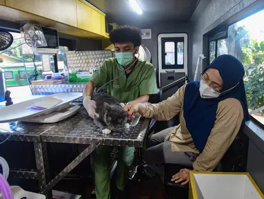 Dokter hewan memeriksa kucing peliharaan warga pada mobil Klinik Hewan Keliling di halaman Kantor Kelurahan Srengseng sawah, Jakarta Selatan, Rabu, 15/ Juli 2026. (KLY/ Arie Basuki)