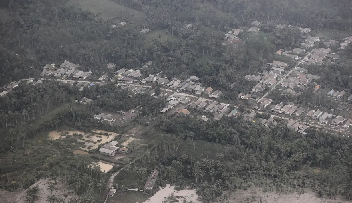 Sebuah desa tertutup abu letusan Gunung Semeru di Kabupaten Lumajang, Provinsi Jawa Timur, Minggu (5/12/2021). Badan Nasional Penanggulangan Bencana (BNPB) menyatakan, korban meninggal akibat Gunung Semeru meletus mencapai 13 orang. Sementara 41 orang yang mengalami luka-luka. (AP Photo/Trisnadi)