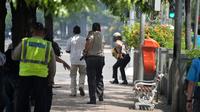Polisi mengejar pelaku yang diduga bersembunyi di dalam sebuah kafe pasca ledakan di pospol Sarinah, Jakarta, Kamis (14/1). Baku tembak terjadi di depan Sarinah setelah suara ledakan ketiga terjadi.  (AFP PHOTO/Bay Ismoyo)