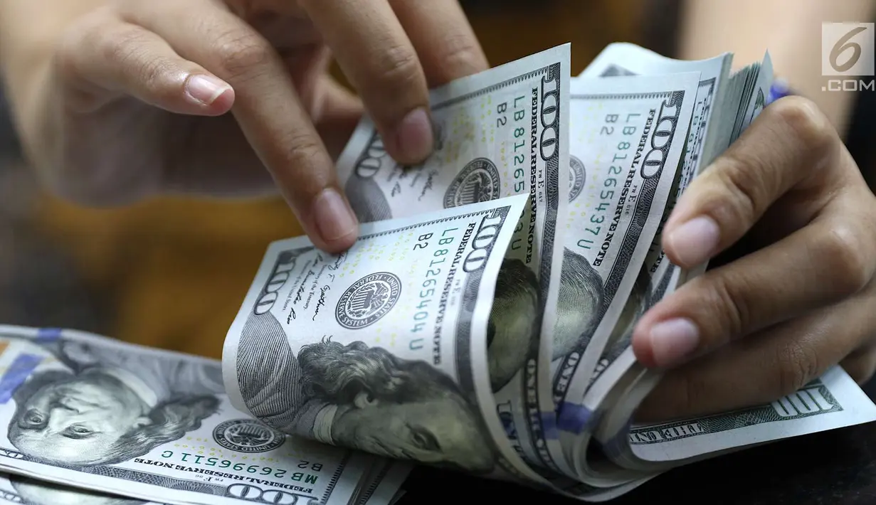 Petugas menghitung uang pecahan dolar Amerika di salah satu gerai penukaran mata uang di Jakarta, Jumat (18/5). Pagi ini, nilai tukar rupiah melemah hingga sempat menyentuh ke Rp 14.130 per dolar Amerika Serikat (AS). (Liputan6.com/Immanuel Antonius)