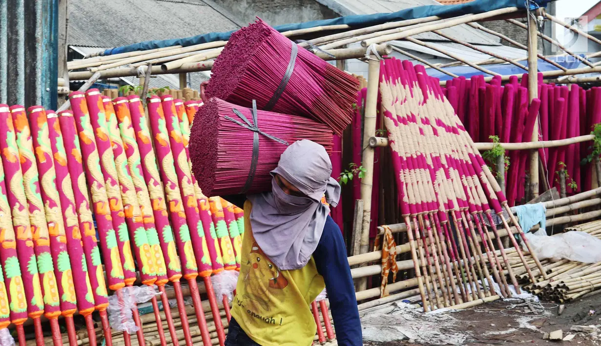 Pekerja membawa hio yang di produksi di Tangerang, Banten, Rabu (7/2). Jelang perayaan imlek pembuat hio mulai kebanjiran pesanan untuk memenuhi kebutuhan kelenteng dengan harga berkisar 12 hingga 16 ribu tergantung ukuran. (Liputan6.com/Angga Yuniar)