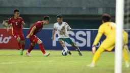 Pemain Timnas Indonesia U-19, Marselino Ferdinan (tengah) berusaha melewati hadangan pemain Vietnam saat laga Grup A Piala AFF U-19 2022 antara Timnas Indonesia U-19 melawan Timnas Vietnam U-19 di Stadion Patriot Candrabhaga, Bekasi, Jawa Barat, Sabtu (2/7/2022). (Bola.com/Ikhwan Yanuar)