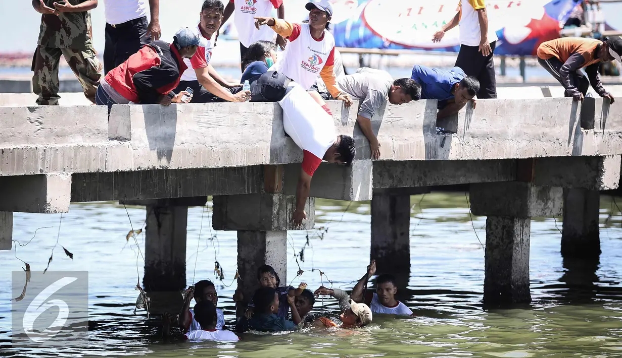 Warga berusaha menolong seorang anak kecil yang terjatuh ke laut di dermaga Muara Angke, Jakarta, Kamis (24/3). Akibat kelalaian ibunya seorang anak tercebur ke laut dan langsung di selamatkan warga dan prajurit TNI AL. (Liputan6.com/Faizal Fanani)