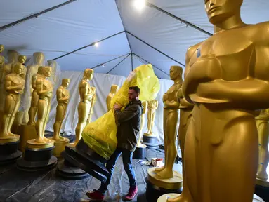 Pekerja membawa patung Oscar yang masih terbungkus untuk diberi sentuhan terakhir oleh seniman di Hollywood, California, 21 Februari 2017. Penganugerahan Academy Awards ke-89 akan diselenggarakan pada Minggu (26/2) waktu setempat. (Frederic J. Brown/AFP)