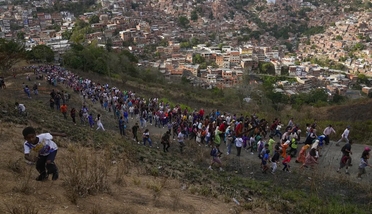 Umat Nasrani mengikuti Via Crucis atau Jalan Salib pada peringatan Jumat Agung di lingkungan Petare, Caracas, Venezuela, 15 April 2022. Prosesi ini memperingati minggu terakhir kehidupan duniawi Yesus Kristus yang berpuncak pada penyaliban-Nya pada Jumat Agung. (AP Photo/Ariana Cubillos)