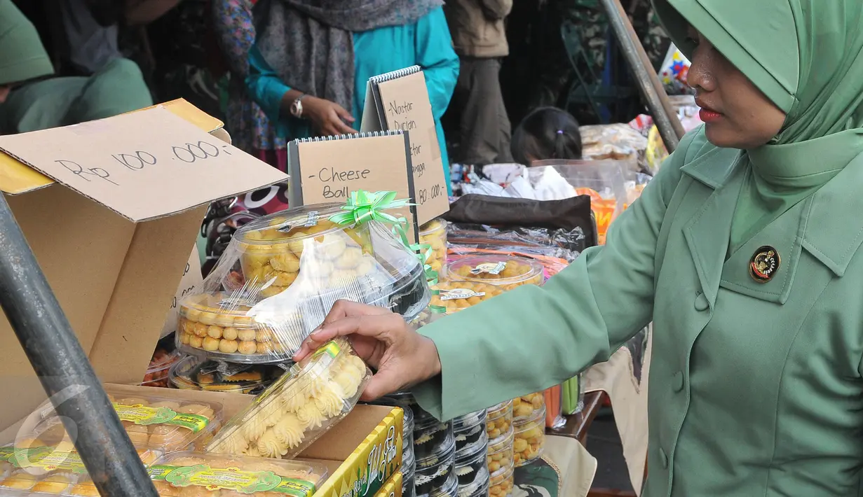 Seorang PNS membeli kue kering saat bazar murah dalam rangka menyambut Idul Fitri 1436 H, di Lapangan Kostrad, Jakarta, Selasa (7/7/2015). Bazar ini dikhususkan bagi para prajurit dan PNS di lingkungan Kostrad. (Liputan6.com/Herman Zakharia)