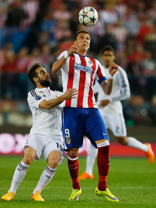 Penyerang Atletico Madrid,  Mario Mandzukic mengontrol bola dari kejaran pemain madrid Dani Carvajal di leg 8 besar Liga Champions di Vicente Calderon, Spanyol Rabu (15/4/2015). Atletico Madrid bermain imbang 0-0 dengan Real Madrid. (Reuters/Sergio Perez)