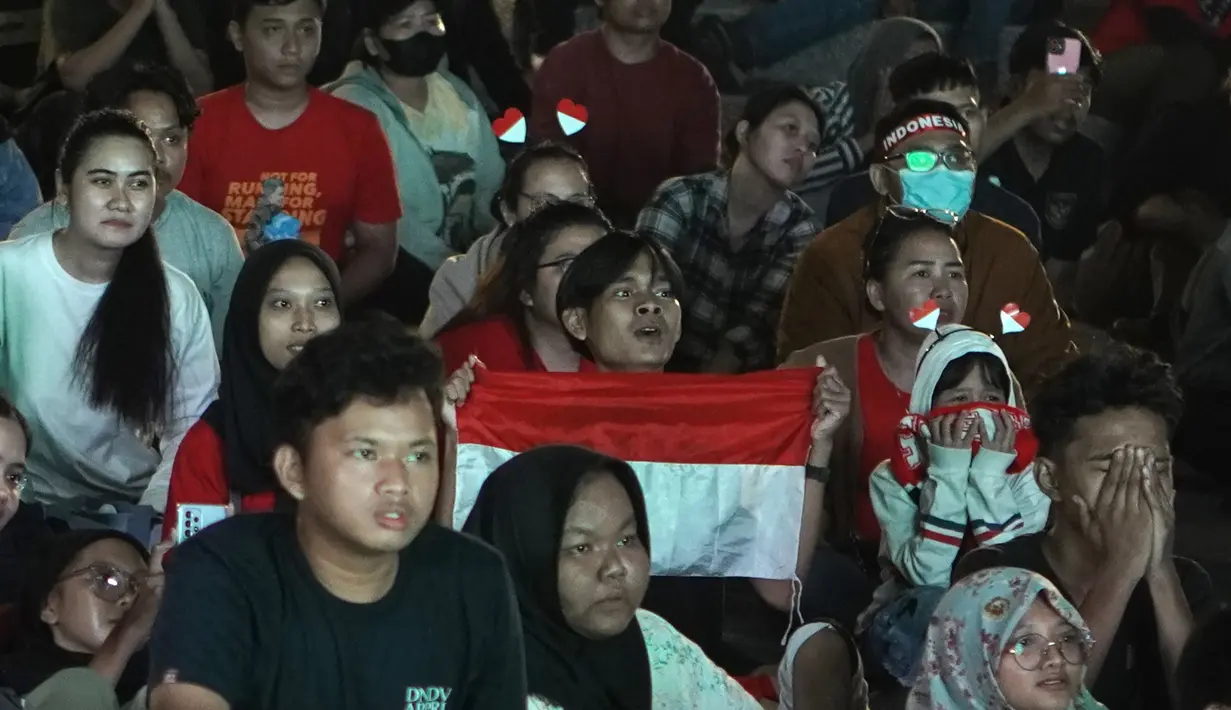 Wajah tegang para suporter Indonesia saat acara nonton bareng laga perebutan tempat ketiga Piala Asia U-23 2024 antara Timnas Indonesia U-23 menghadapi Irak di Plaza Kemenpora, Senayan, Jakarta Pusat, Kamis (2/5/2024) malam WIB. (Bola.com/Afi)