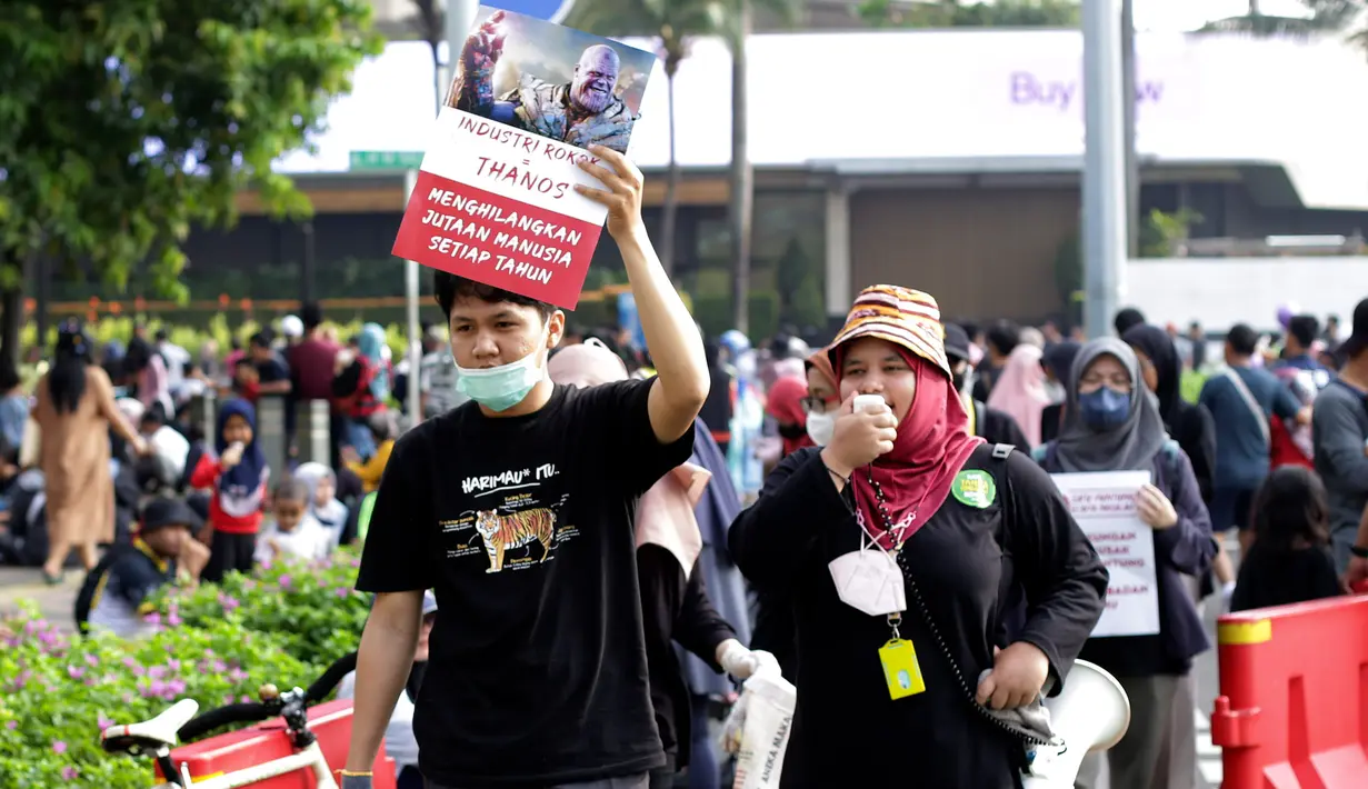 Relawan berorasi sambil melakukan aksi memunguti puntung rokok di area Hari bebas kendaraan bermotor (HBKB) atau car free day (CFD), kawasan Jalan Sudirman-MH Thamrin, Jakarta, Minggu (28/5/2023). (Liputan6.com/Johan Tallo)