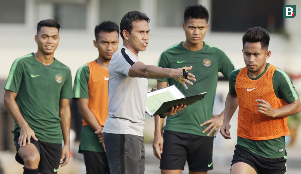 Pelatih Timnas Indonesia, Bima Sakti, memberikan arahan kepada anak asuhnya saat latihan di Universitas Kasetsart, Bangkok, Kamis (15/11). Latihan ini persiapan jelang laga Piala AFF 2018 melawan Thailand. (Bola.com/M. Iqbal Ichsan)