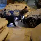 Seorang pria terjatuh saat mendorong mobil yang terjebak salju tebal di Madrid, Spanyol, Jumat (8/1/2021). Badai Filomena mengakibatkan salju lebat turun di Madrid dan sebagian besar wilayah Spanyol. (OSCAR DEL POZO/AFP)