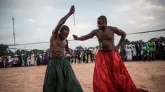 Warga kelompok etnis Joles mempersiapkan diri untuk menunjukkan kekuatan sihir yang berasal dari air spiritual, yang membuat mereka kebal dari senjata tajam saat kampanye Presiden Yahya Jammeh di Bikama, Gambia (24/11). (AFP/Marco Longari)